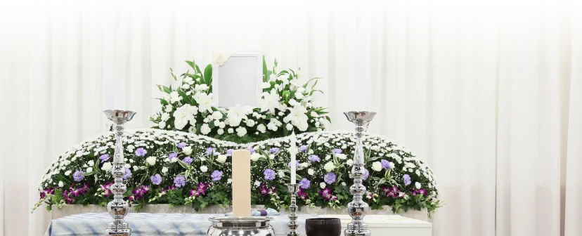 葬儀場で胸に手を当てて立っている男性スタッフ